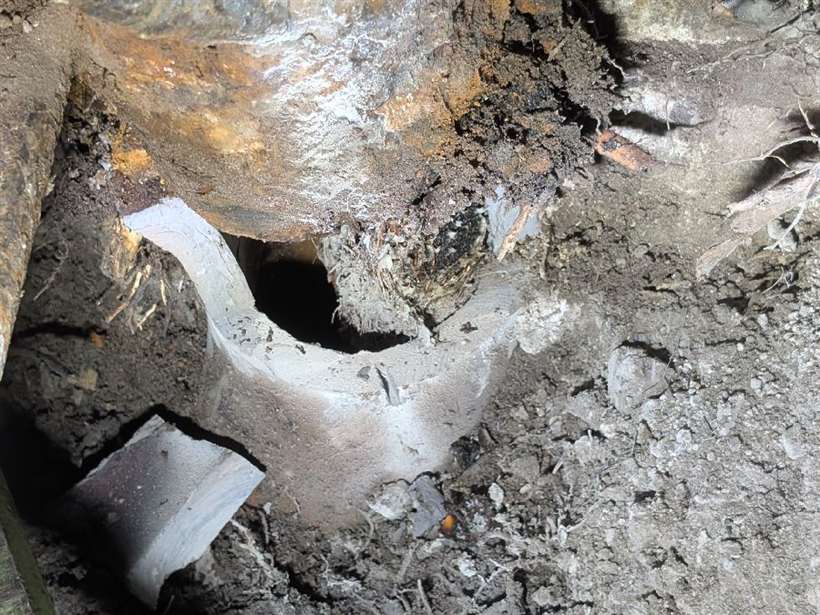 The corroded cast iron sewer and broken clay junction exposed in the excavation at the South Yarra apartment block