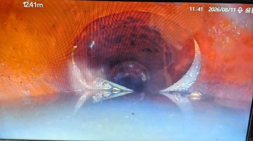 Drain camera view of a dislodged pipe joint with the pipes out of alignment