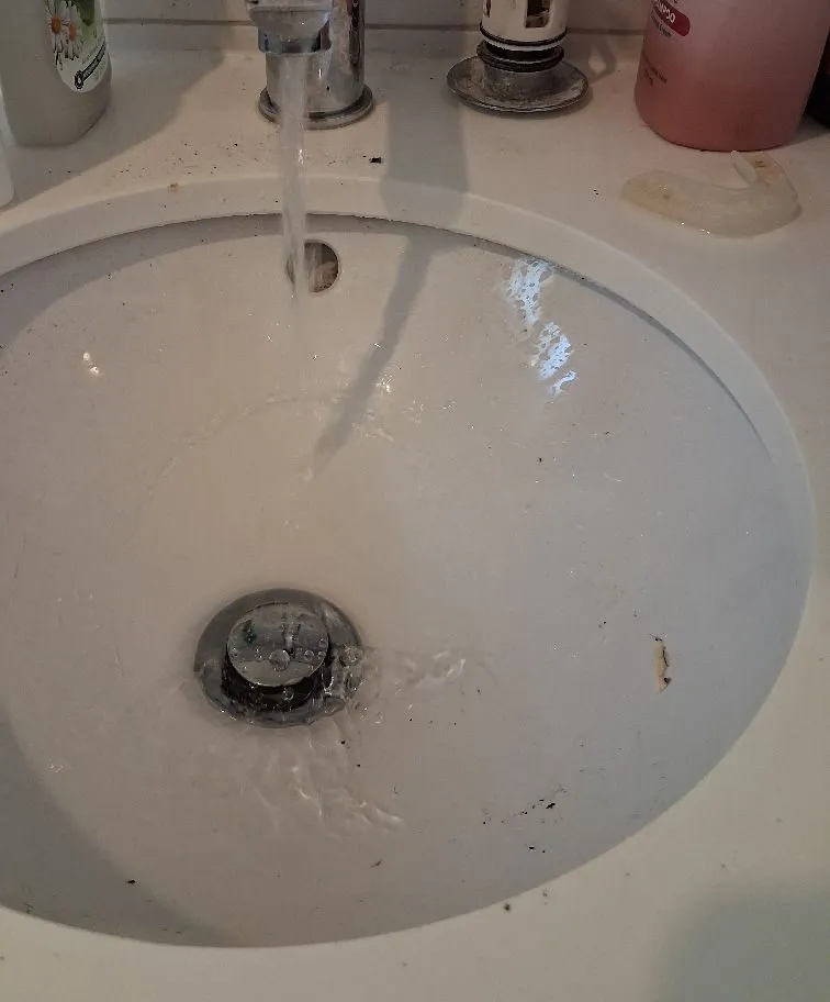 A bathroom basin draining freely after a Zebra Plumbing clear, water running from the tap