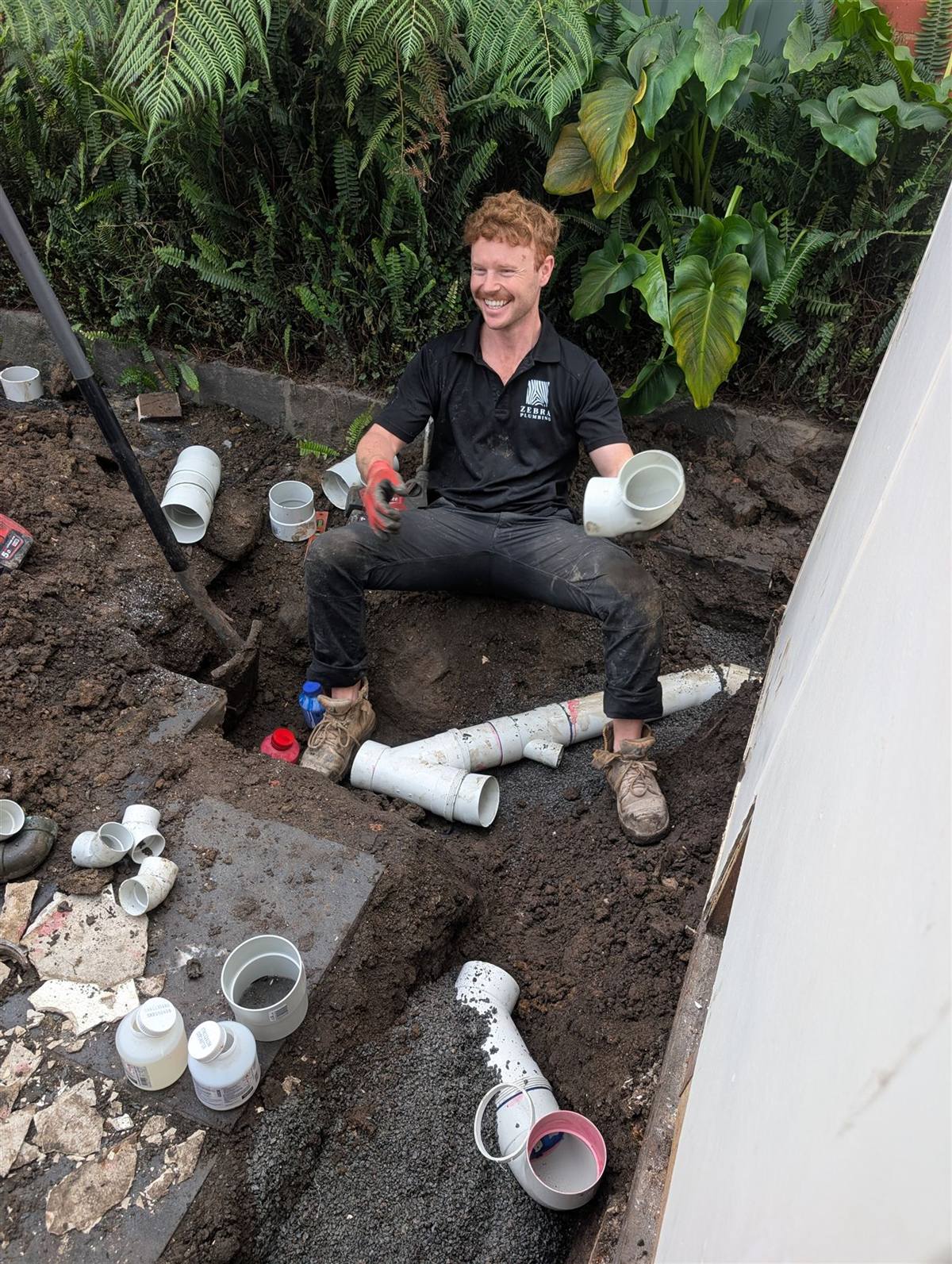Lucas from Zebra Plumbing fitting new PVC stormwater drainage in a trench bedded with screenings